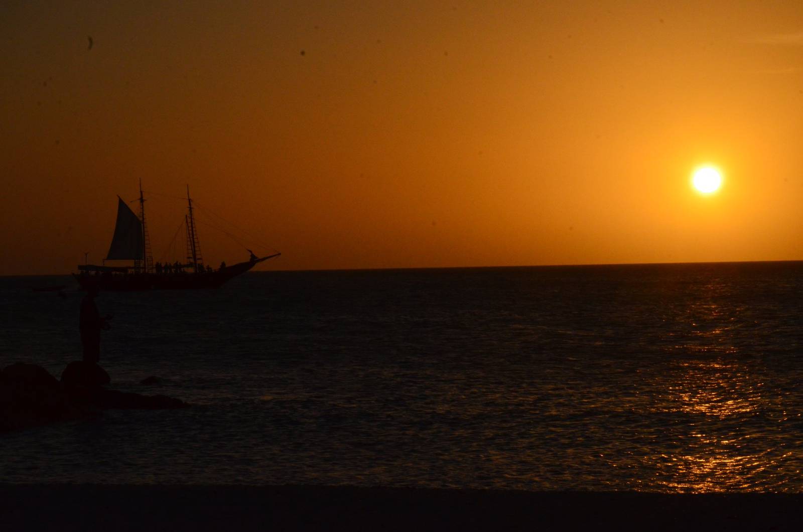 A sailing ship crossing a blazing sunset off Aruba