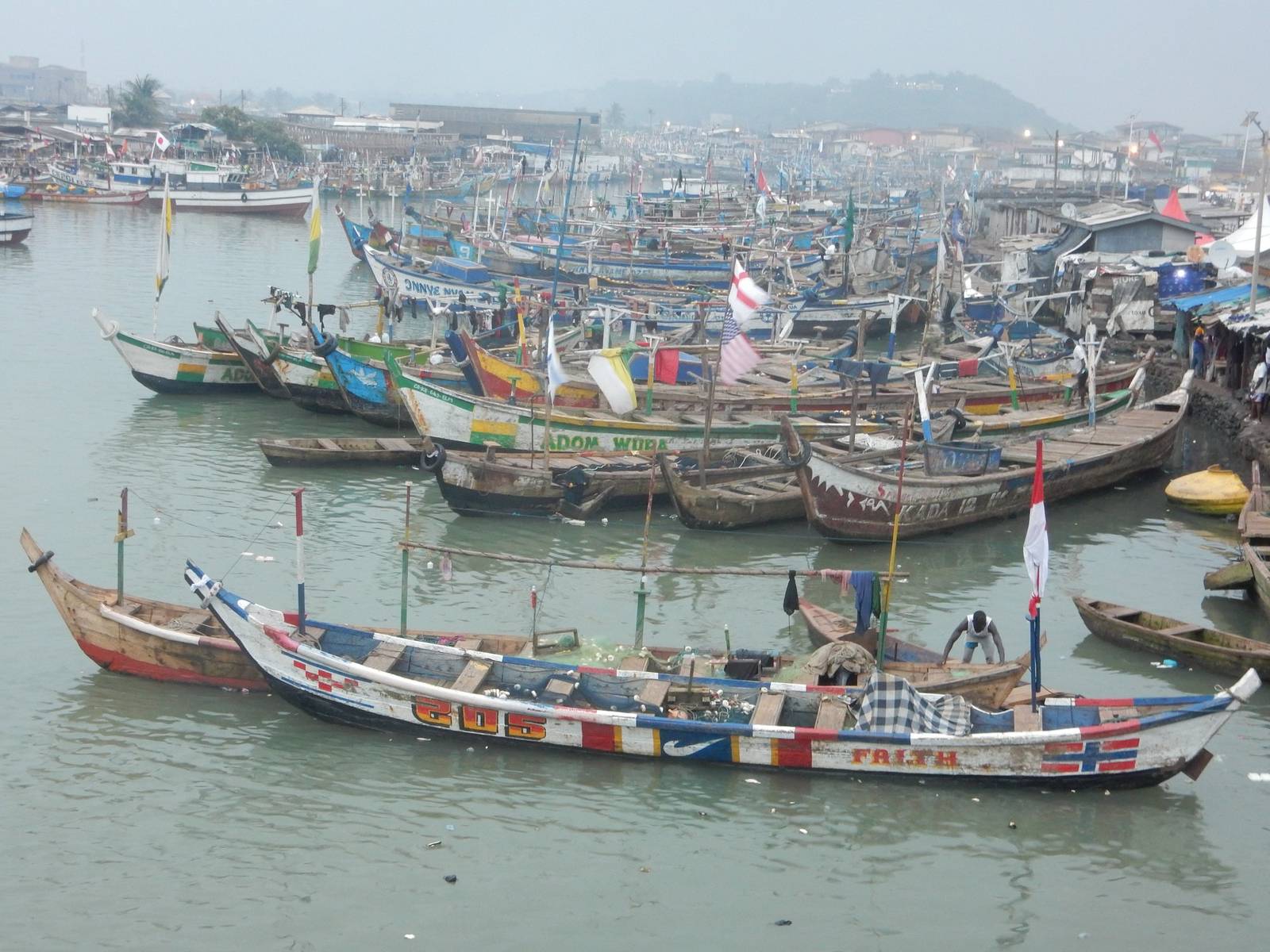 Painted fishing canoes crowding a harbour on Ghana's coast