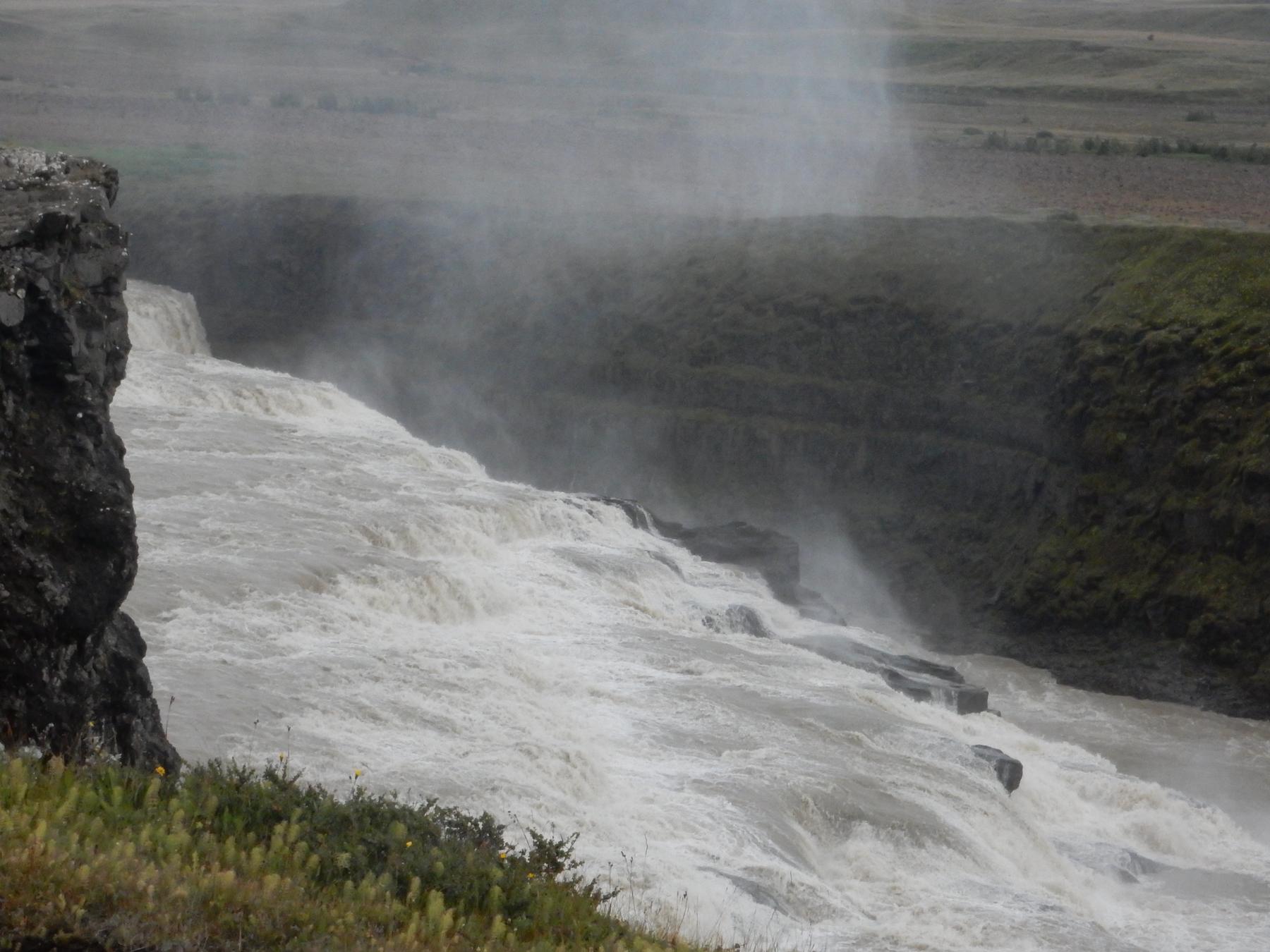 Glacial water thundering into a misty canyon in Iceland